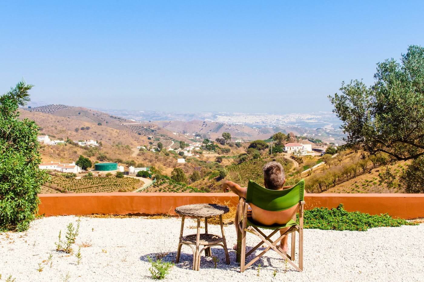 Man relaxing in a chair overlooking a scenic mountain view